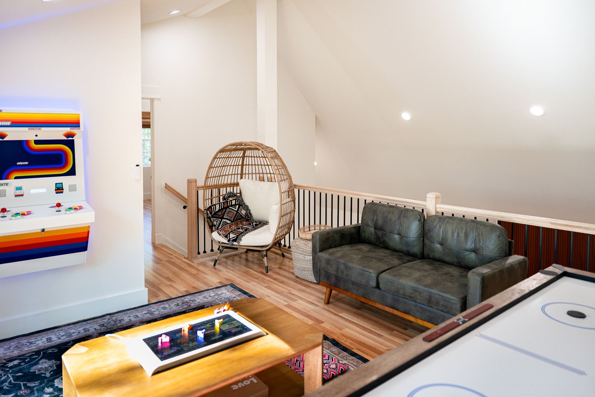 The Stag's loft lounge: a leather sofa, an egg chair and the Polycade arcade beside the stair rail